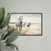 Running Horses on the Beach Wall Art - 3x2 Aspect Ratio - Black Floating Frame Canvas on a Wall with a Plant