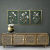 Dark Moody Botanical Wall Art Set of 3, Wild Cosmos Flowers, Dark Green Background, Antique Gold Frame, Dark Academia Cottagecore Style over a Rustic Cabinet