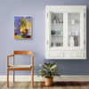 Plant painting in white frame displayed on soft blue wall in dining area near white display cabinet with mugs. Impressionist style potted plant artwork with vibrant purple and yellow background, paired with wooden chair and potted houseplant. Modern botanical wall art perfect for breakfast nook, kitchen, dining room or coffee station area. Colorful kitchen decor that complements Scandinavian or contemporary home style.