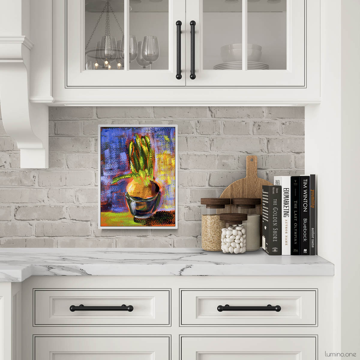 Botanical plant painting in white frame displayed on white painted brick backsplash in elegant kitchen with marble countertops and white cabinets. Impressionist style potted plant artwork with vibrant purple and yellow background, styled with wooden cutting board, spice jars and cookbooks. Perfect for farmhouse kitchen wall decor, modern traditional style, or chef's kitchen art above countertop. Colorful accent piece for neutral white kitchen design.