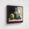 Still life oil painting framed canvas print featuring green apple, dark plums, and green glass bottle with cork arranged on white cloth, displayed in brown floating frame against white background