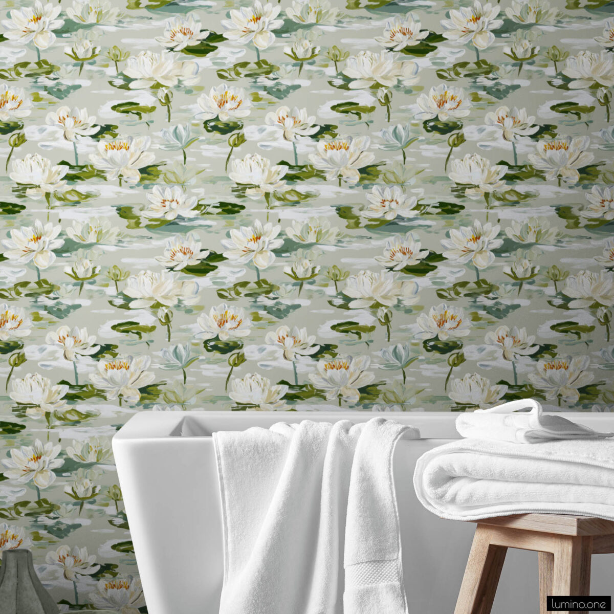 Calming bathroom featuring white water lily botanical wallpaper behind modern white freestanding bathtub with fresh towels, wooden stool, green ceramic vase, and wood plank flooring creating a peaceful spa-like retreat