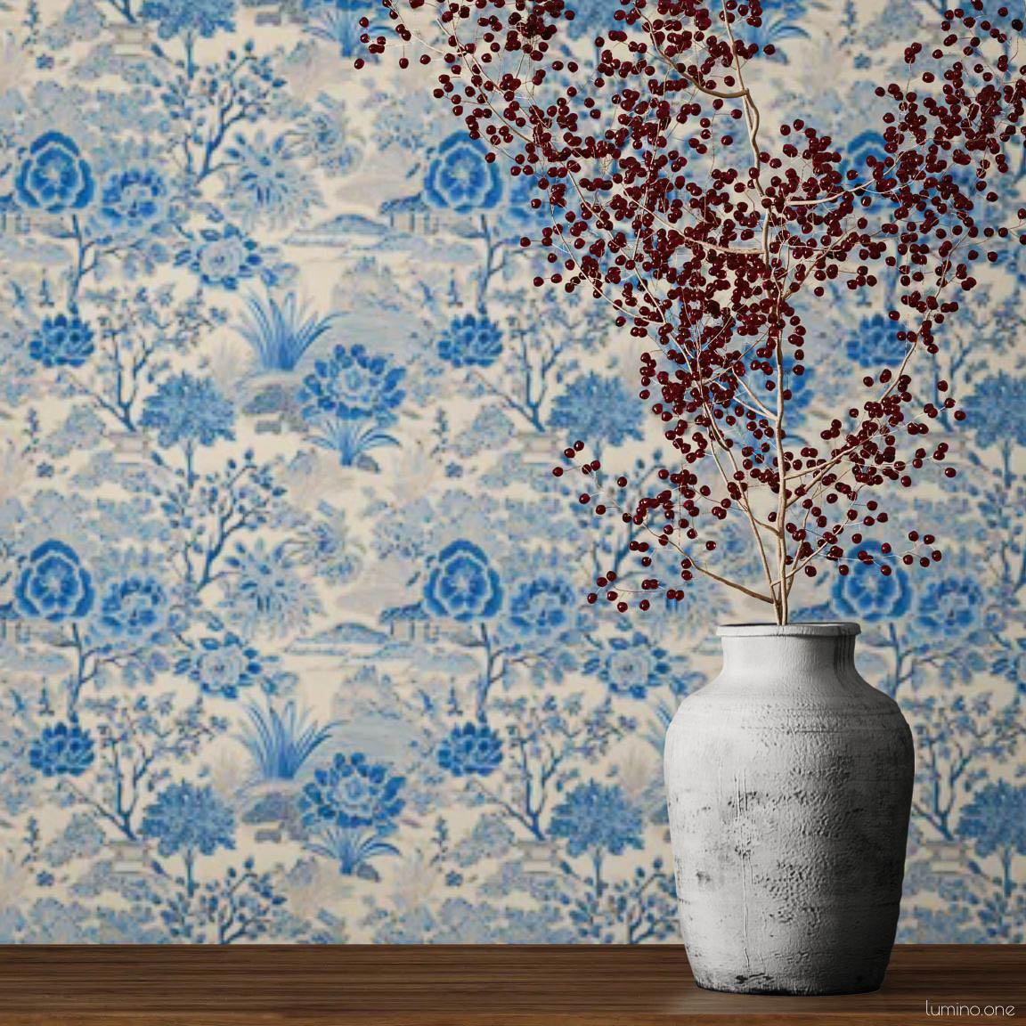 Blue and white toile peel and stick wallpaper covering a full wall, featuring a repeating vintage botanical garden pattern with flowers and trees. Styled with a dark iron candelabra, rustic white vase with red berry branches, and a wood console - living room or dining room accent wall decor.