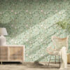 Sage green chinoiserie removable wallpaper with hand-painted birds, pink peonies, and botanical branches in sunlit room with natural rattan credenza, white ceramic lamp, wicker peacock chair, and potted tree