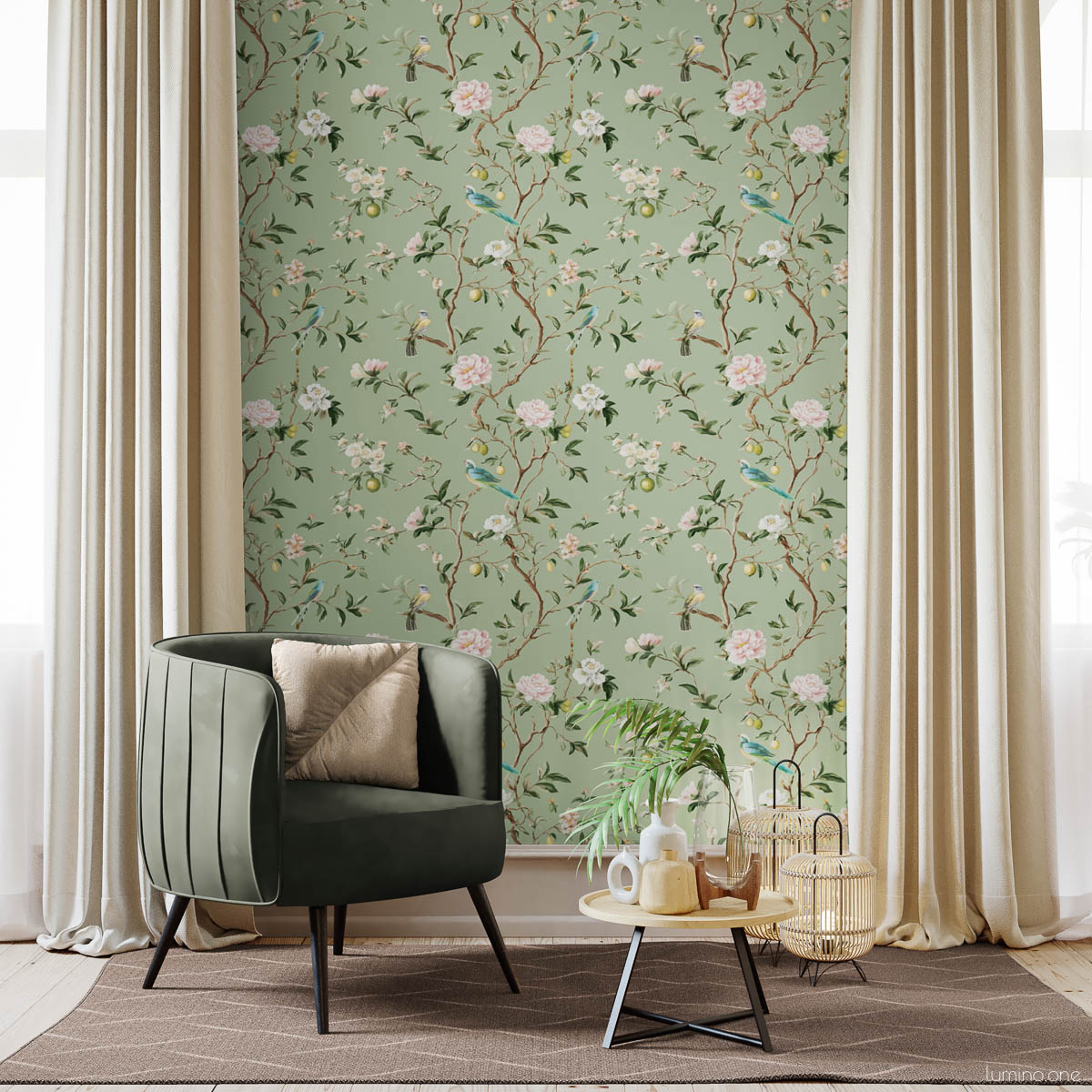 Sage green chinoiserie botanical wallpaper feature wall with hand-painted birds, pink peonies, and lemon branches in bright room with green velvet chair, gold pillow, beige curtains, and natural wood coffee table