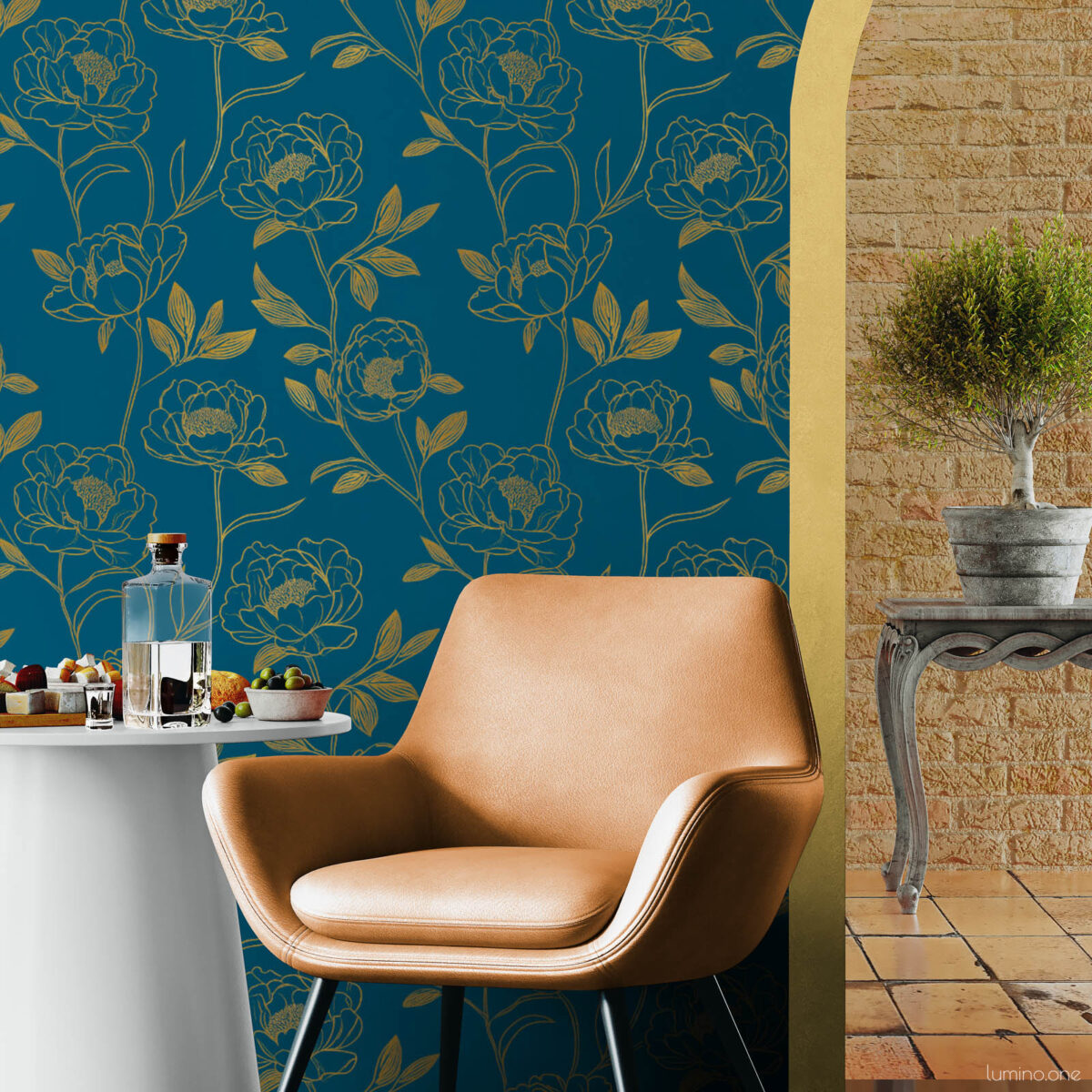 Boho-inspired sitting area with dark teal and gold peony peel and stick wallpaper, styled with a tan leather armchair, round white side table, and a gold arched doorway opening to a stone brick patio